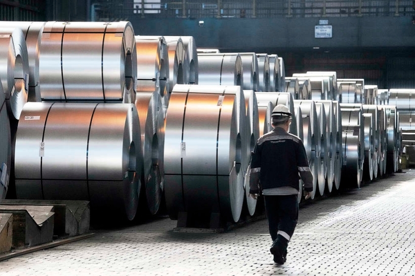 A steelworker walks past steel coils in Duisburg, Germany. Photo: Visual China Group