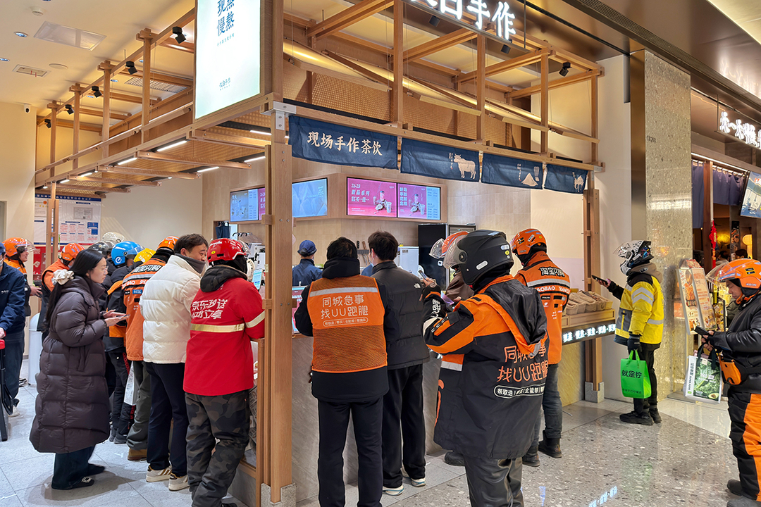 Delivery drivers line up outside a milk-tea shop to pick up orders in Zhengzhou, Henan province, on Feb. 6, 2026. Photo: VCG